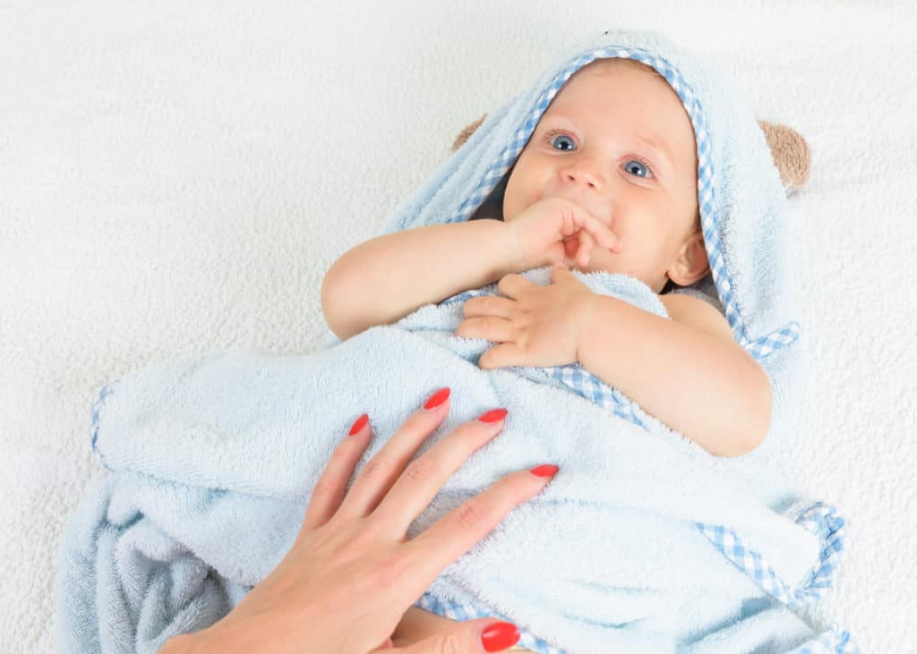 cute baby after bath wrapped in blue towel