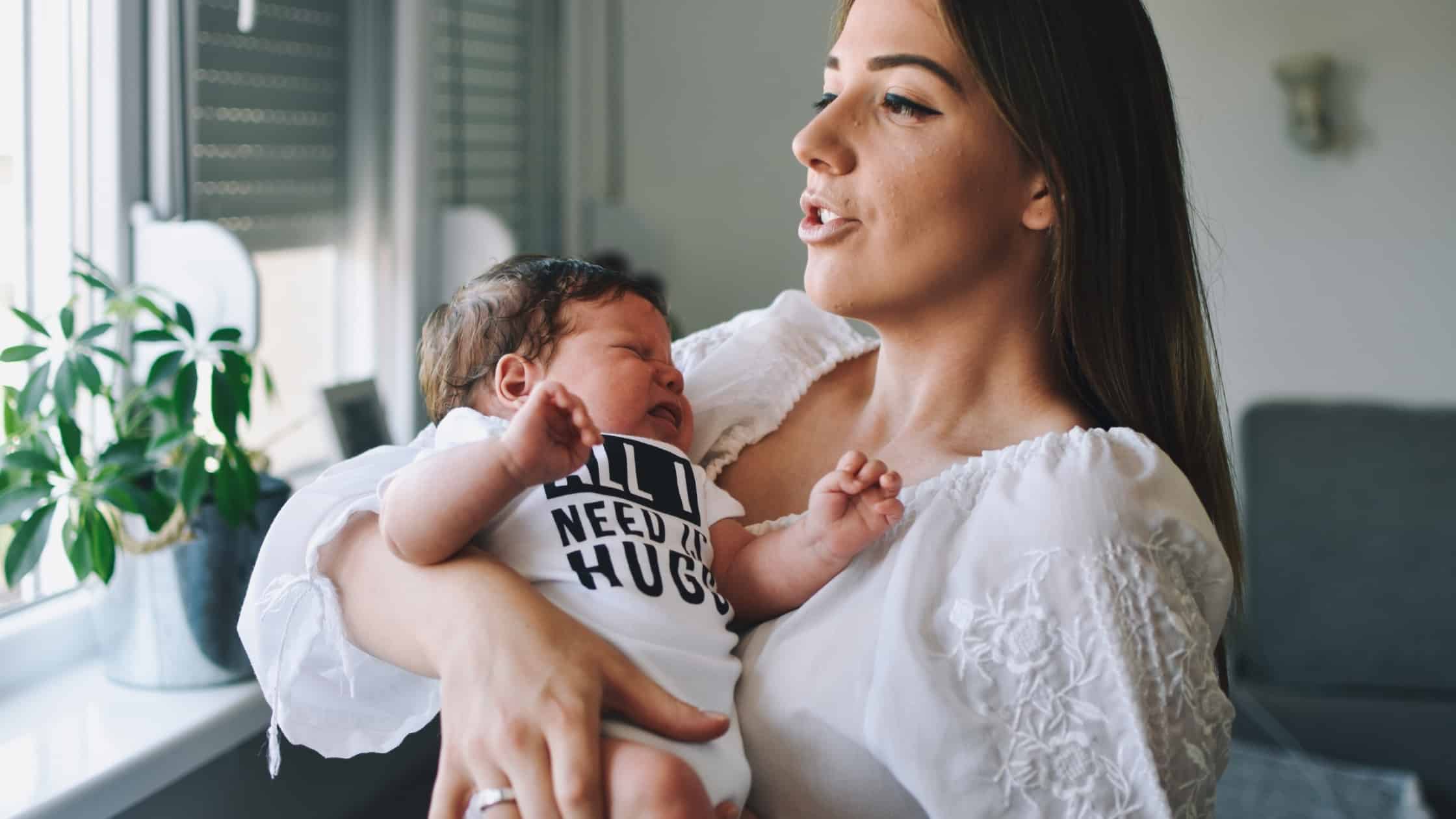 baby crying in mom's arms