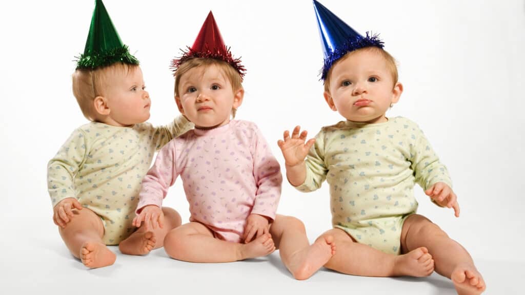 three babies with party hats on