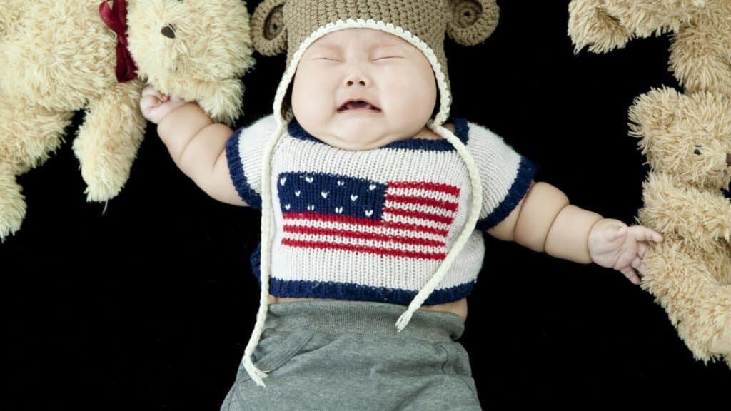 baby on blanket with stuffed animals