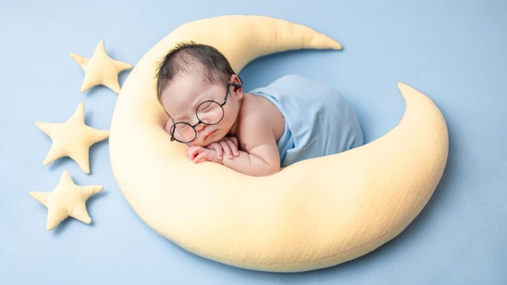 baby sleeping on a moon plush