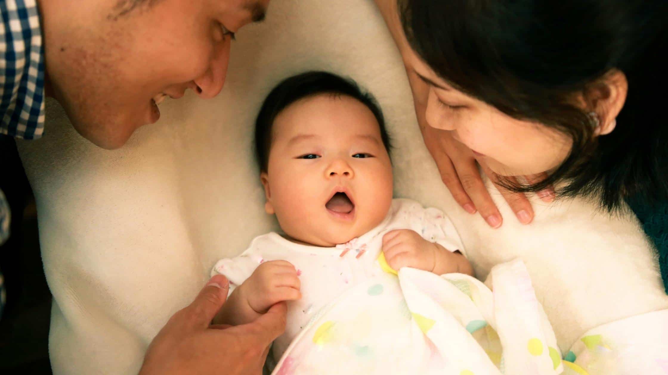 mother and father over newborn baby