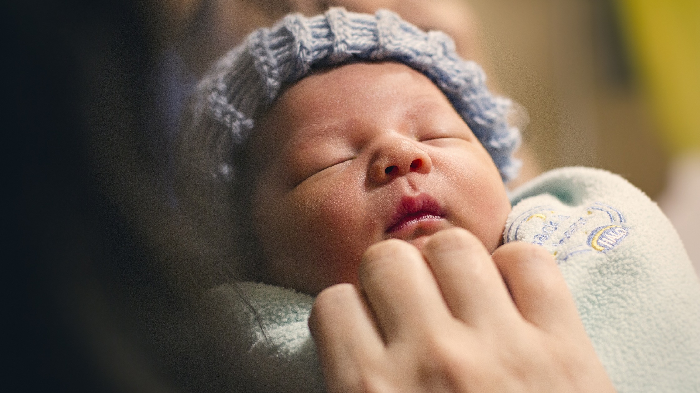 baby sleeping in blue hat