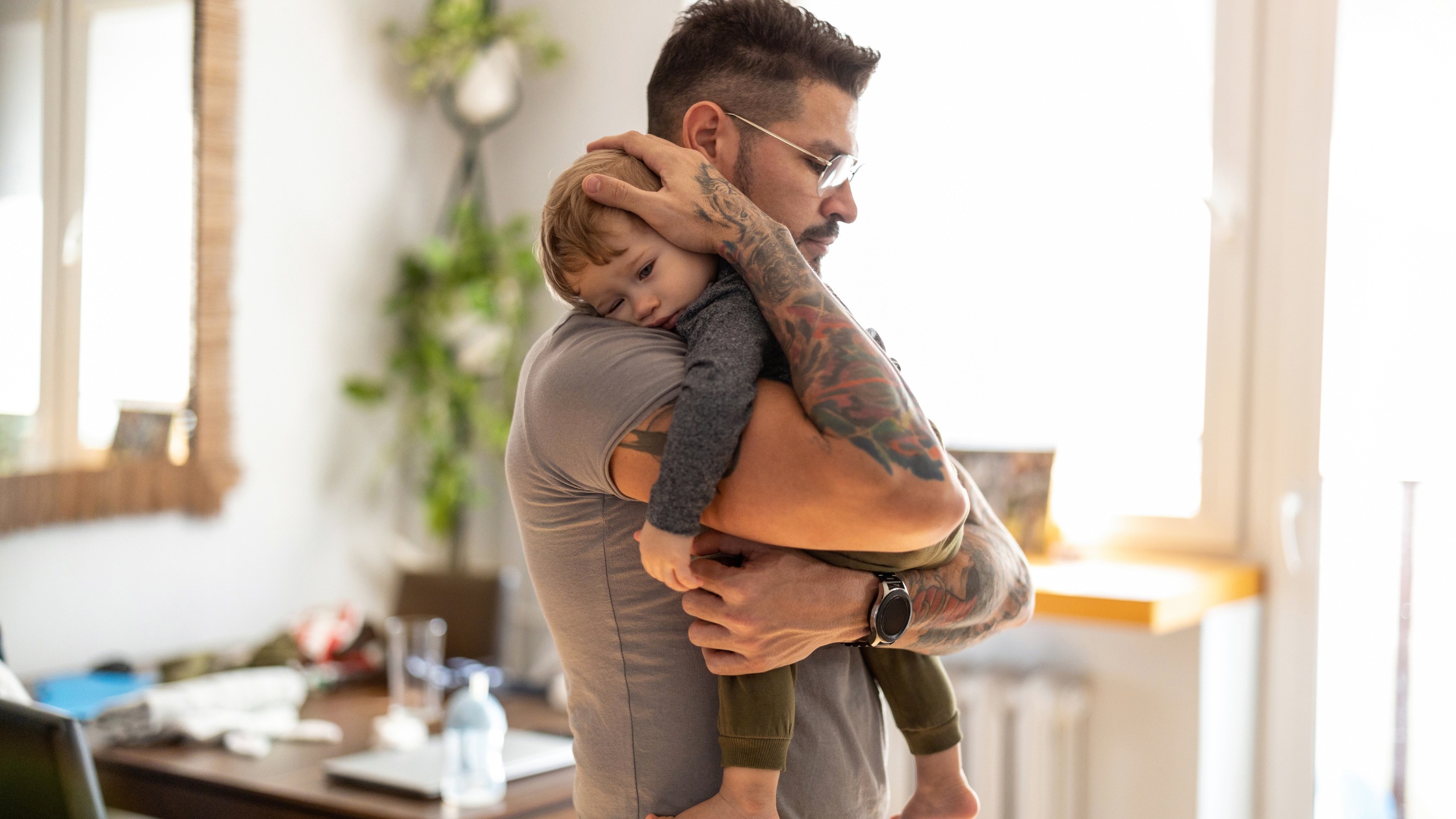 father holding sleeping toddler