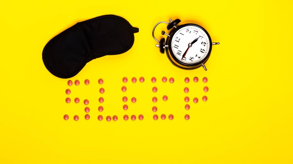 picture of sleep help pills a mask and an alarm clock