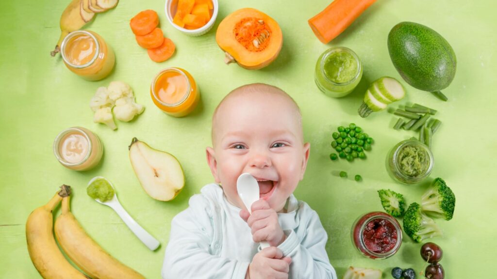 baby surrounded by vegetables and other great first foods
