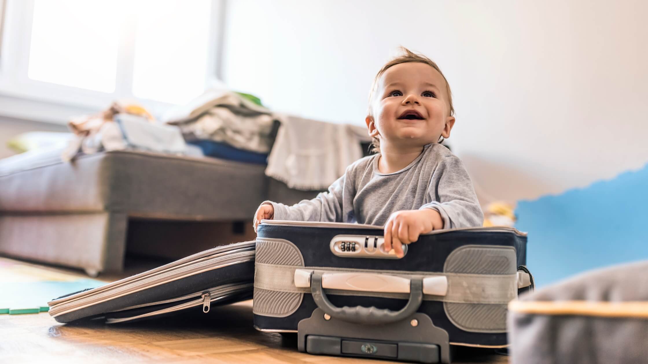 baby playing in a suitcase ready for travel