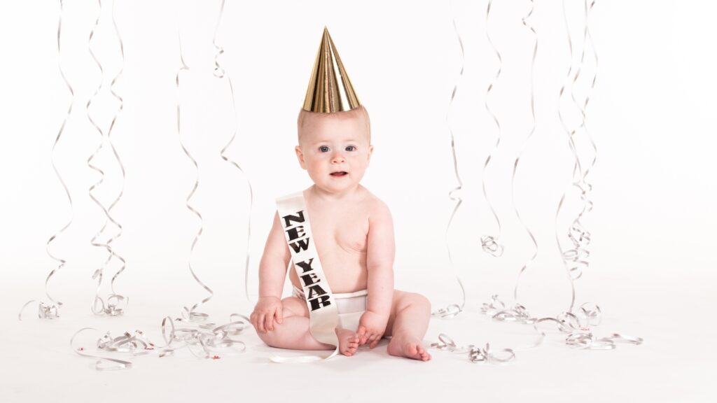 a baby celebrating the new year with a hat and sash
