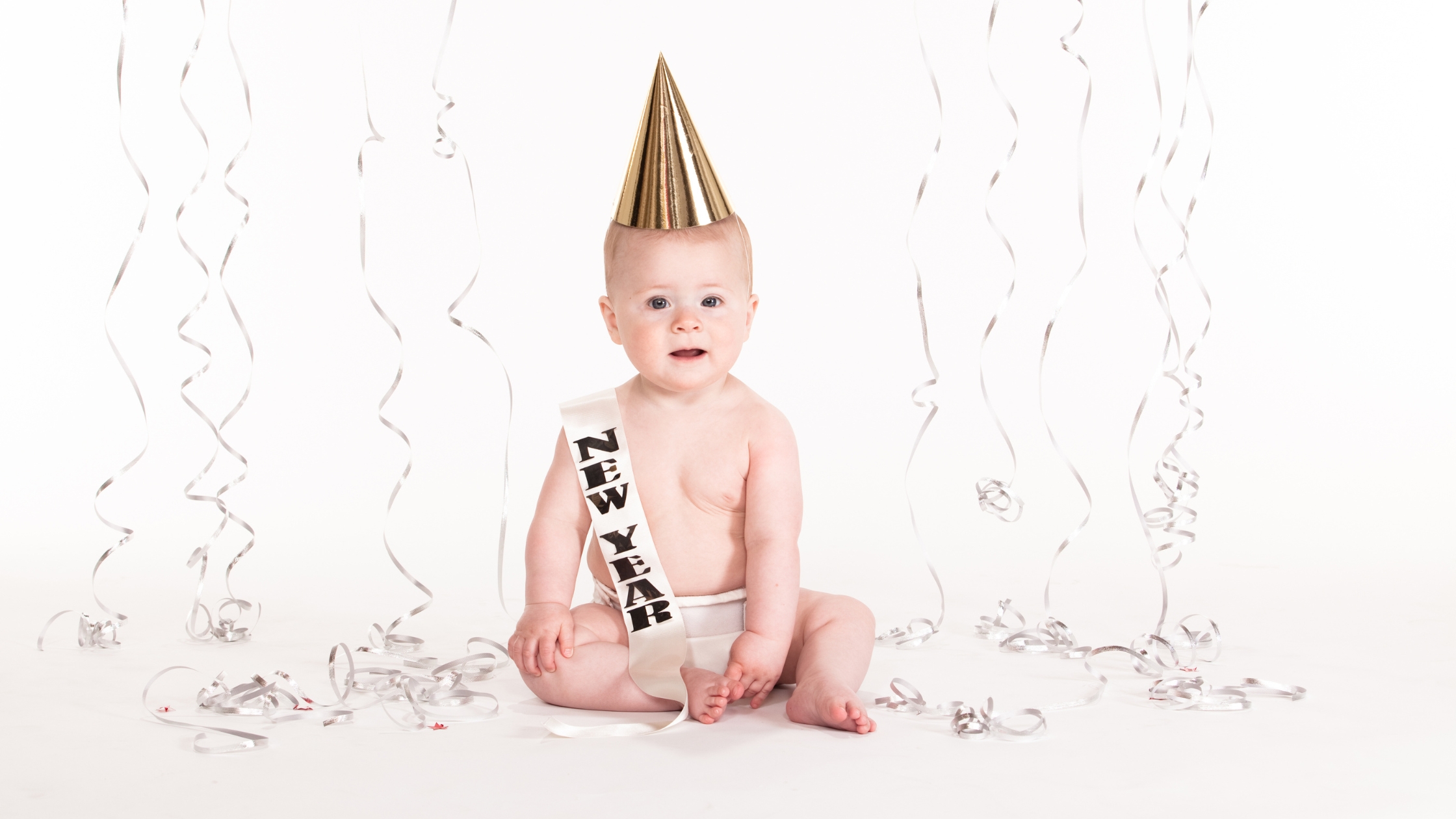a baby celebrating the new year with a hat and sash