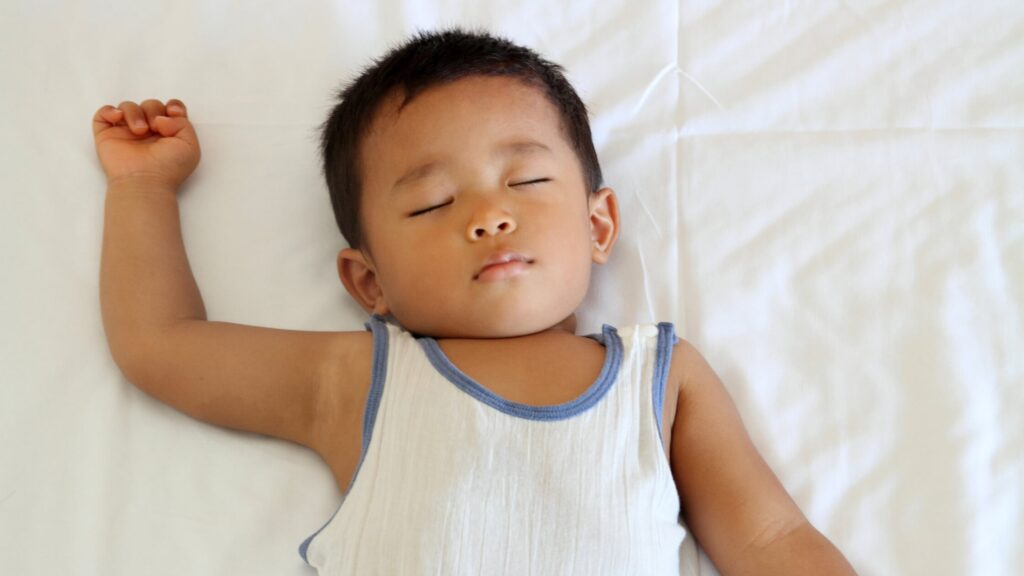 toddler napping on bed