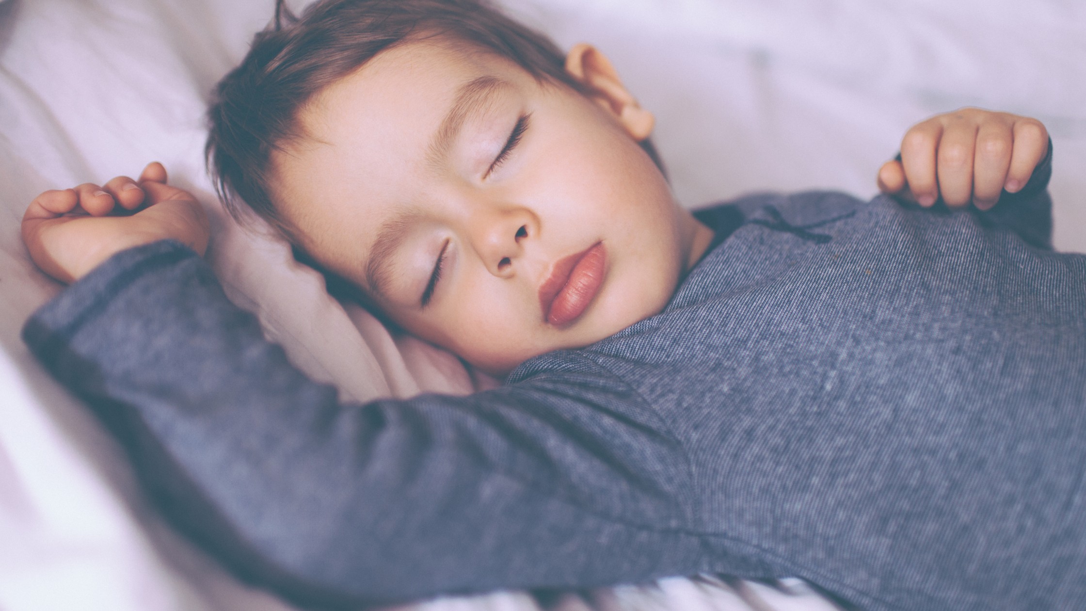 toddler sleeping in their bed