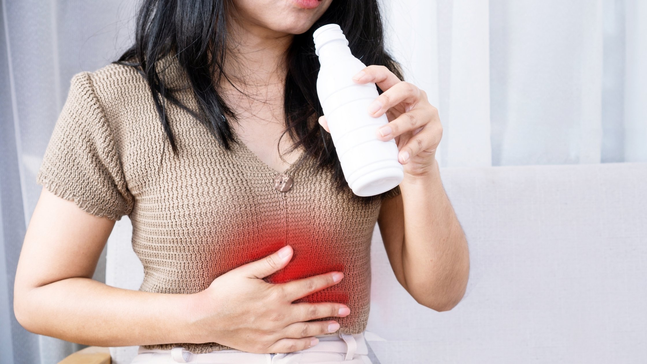 woman clutching belly due to a heartburn flareup during pregnancy