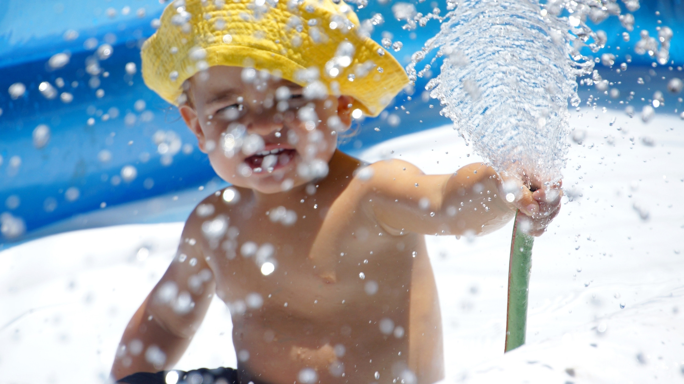baby splashing water on beach