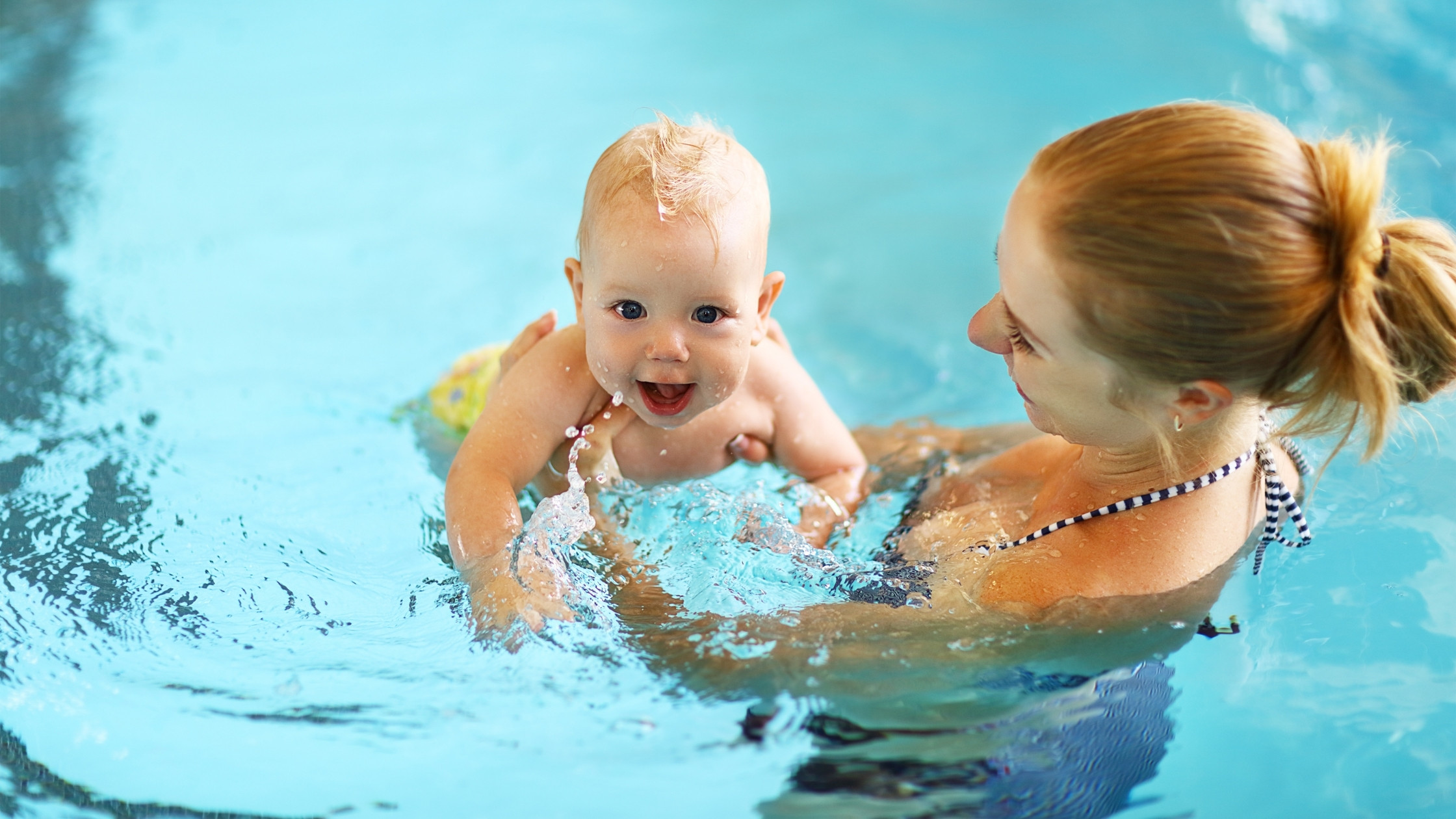 mother and baby swimming in pool summer