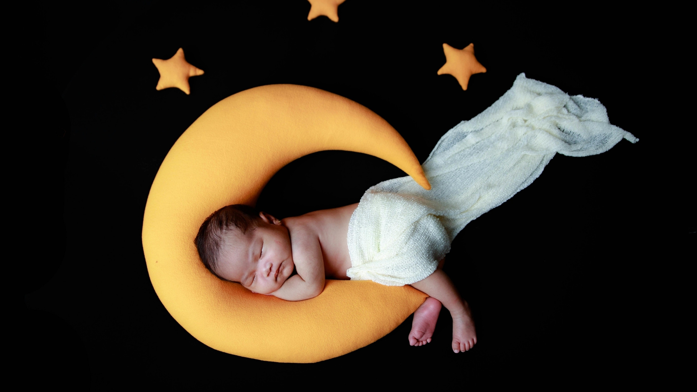 baby sleeping on a moon pillow