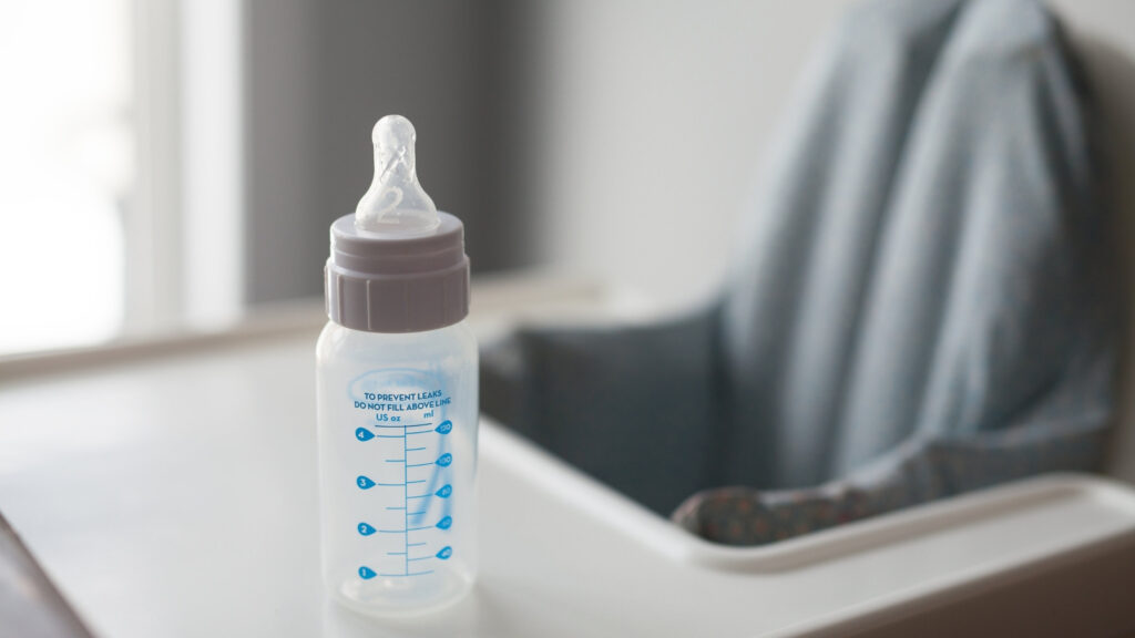 baby milk bottle sitting on high chair