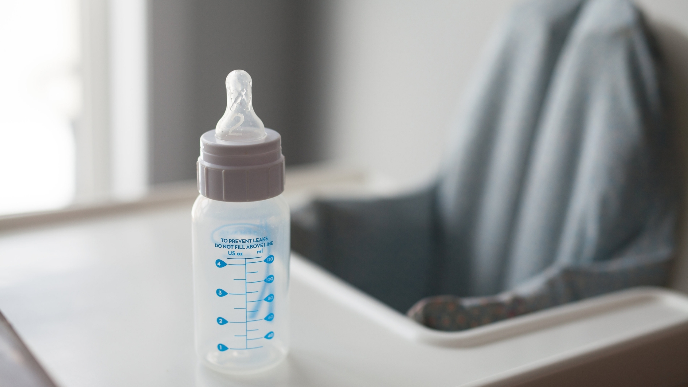 baby milk bottle sitting on high chair
