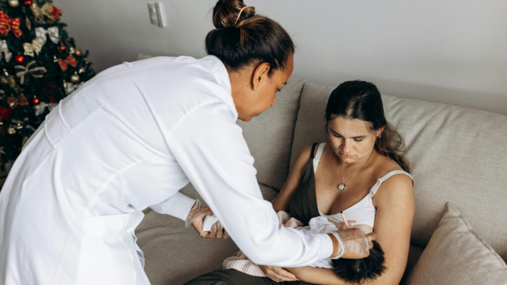 night nurse helping mother feed