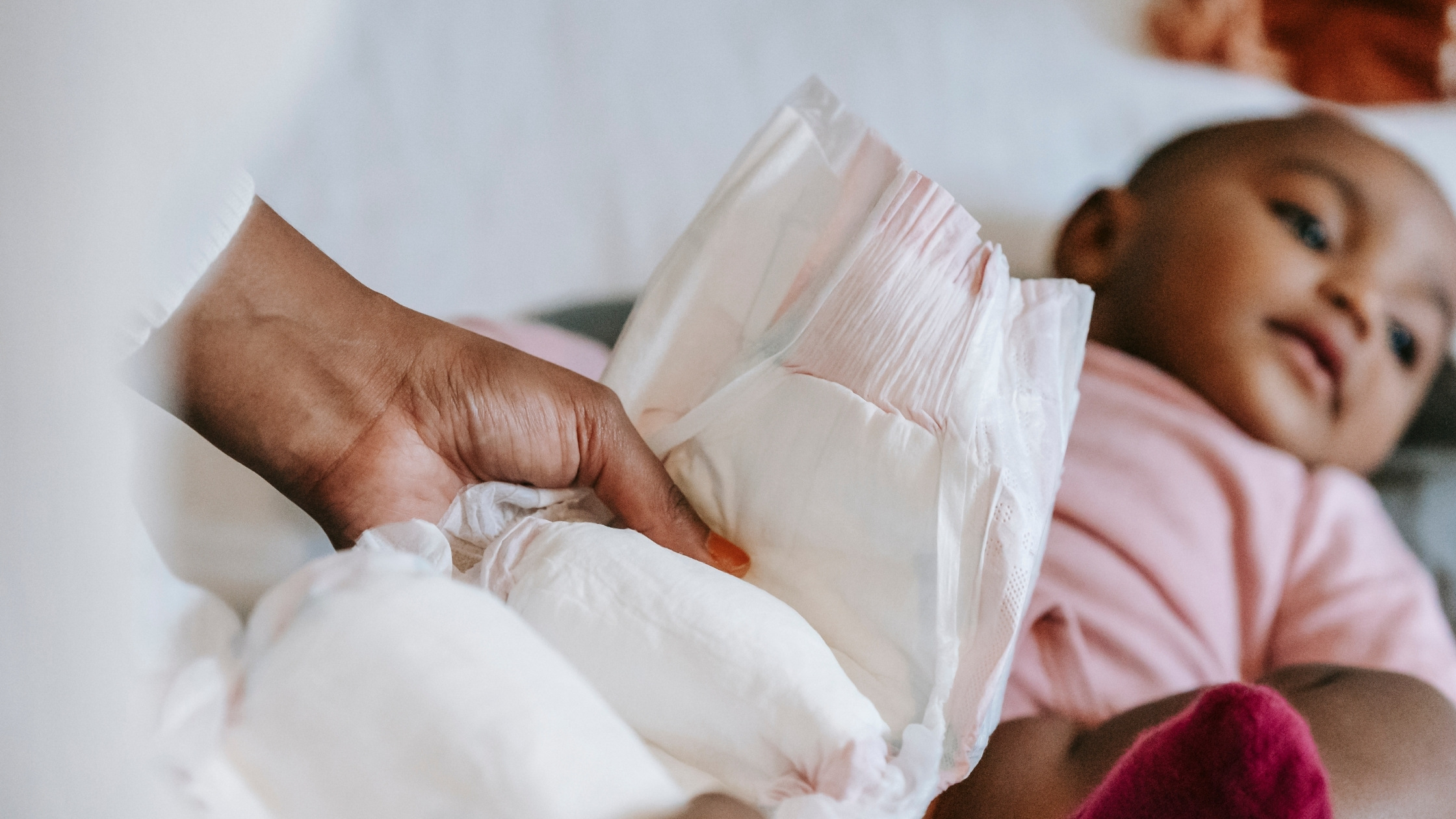 mother changing baby's diaper