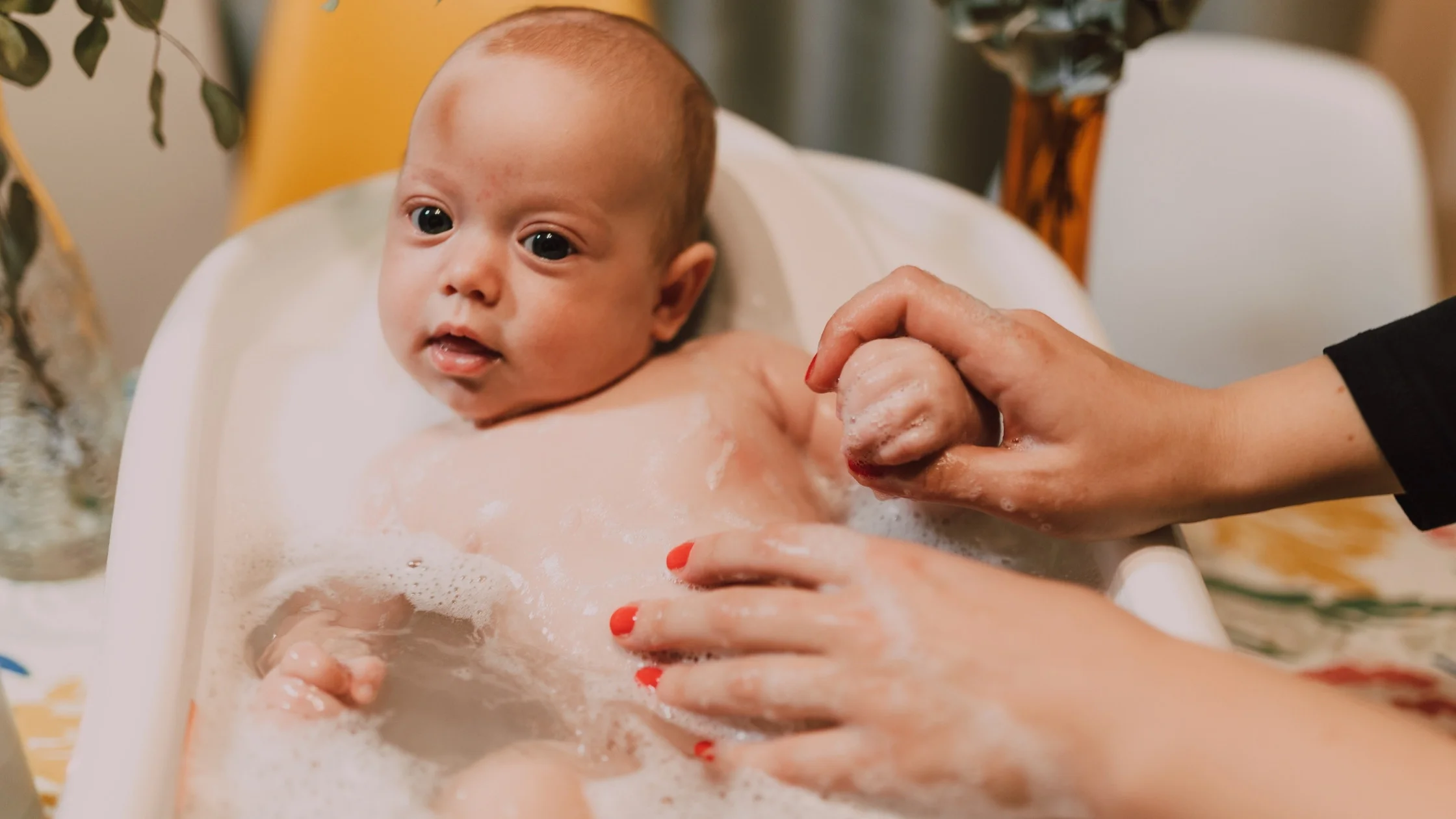 newborn baby being given a bath