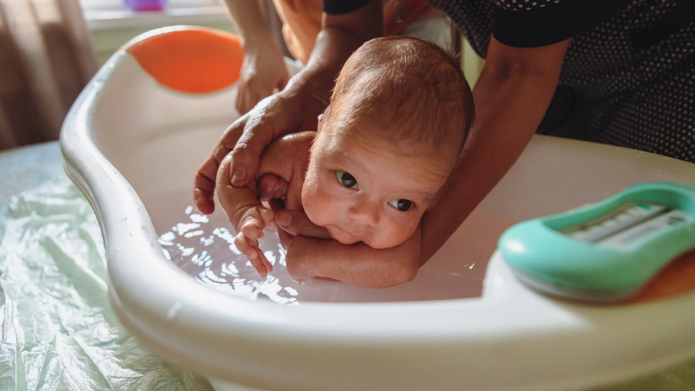newborn baby getting bath by mother