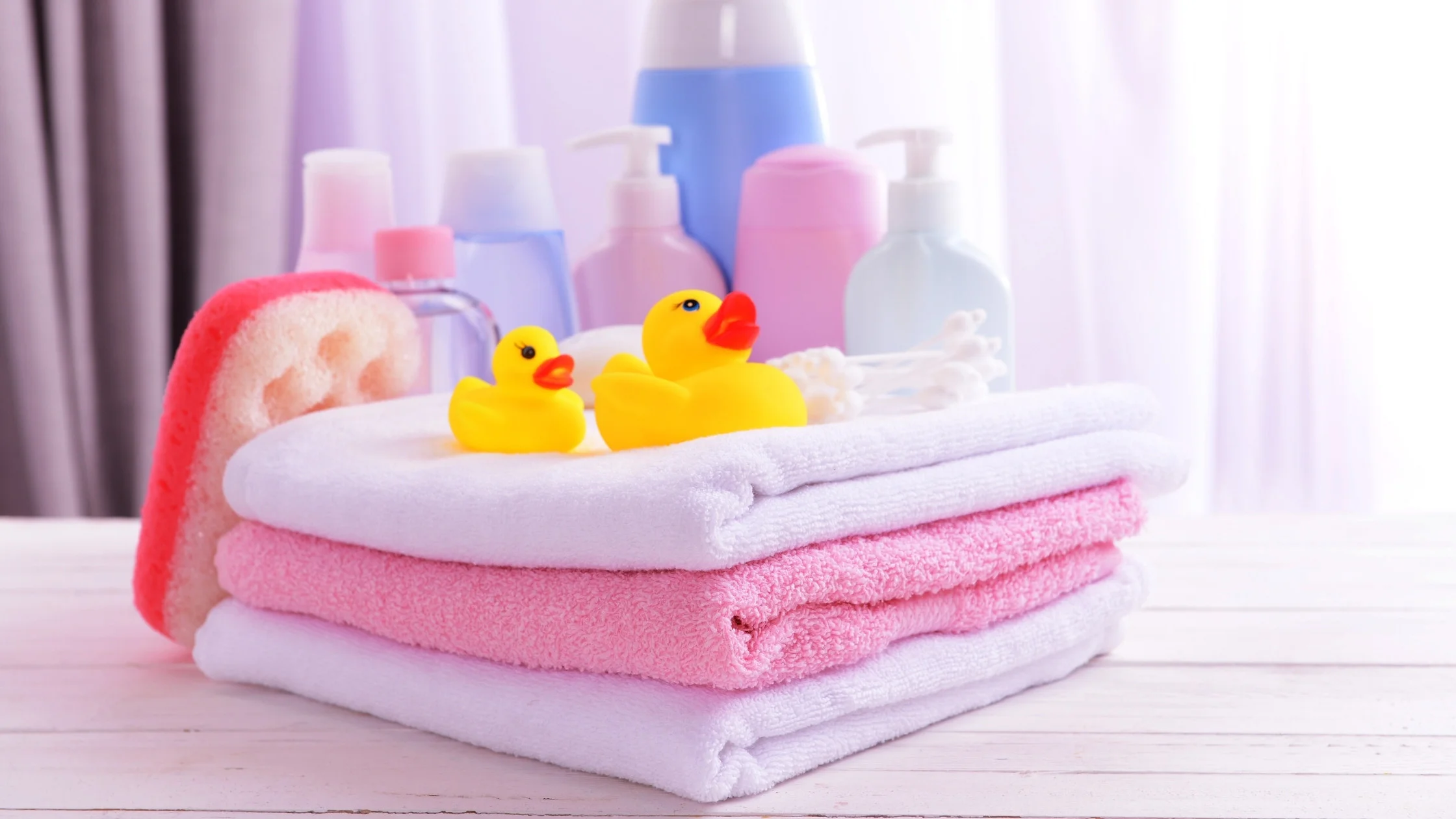 towels, lotion, and other bath time supplies on a table for a baby's bath