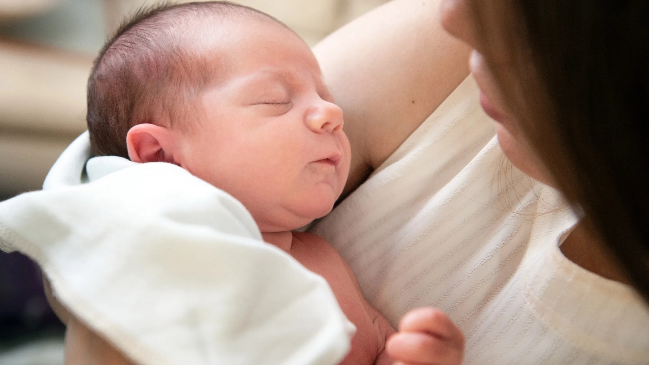 newborn baby being held while sleeping