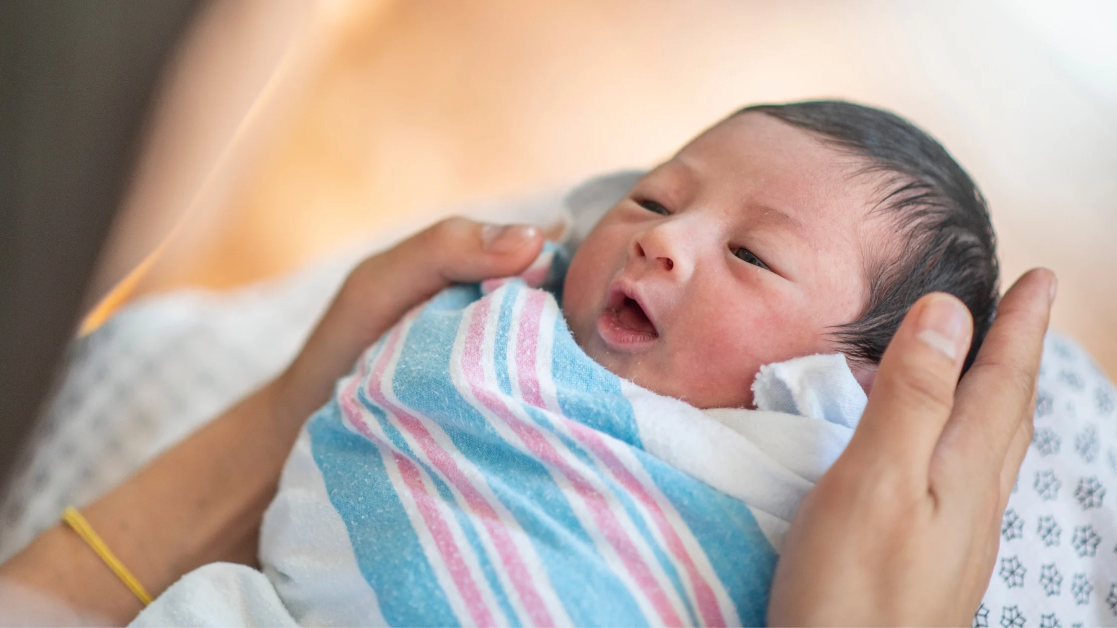swaddled baby in mother's arms