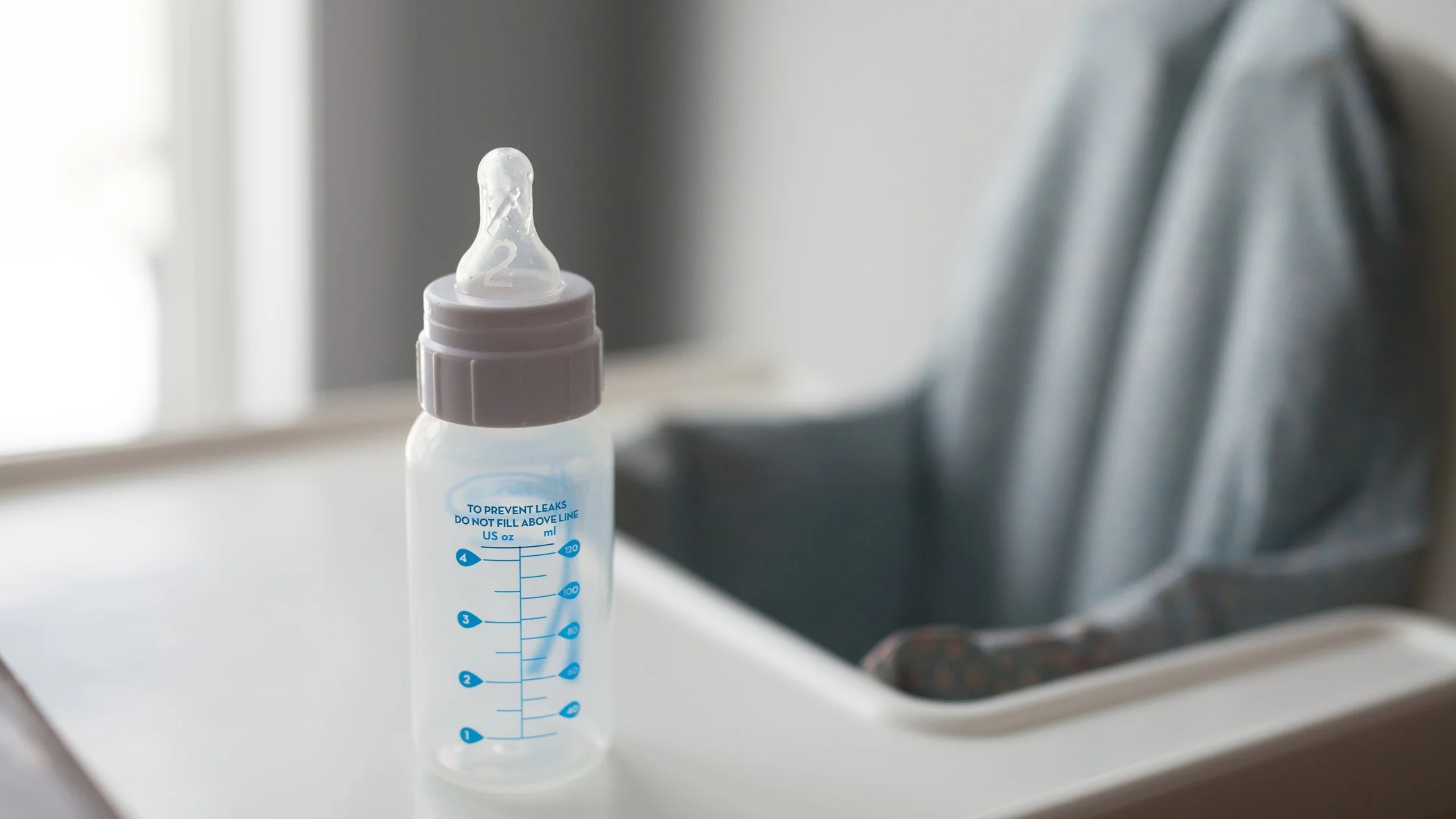 baby milk bottle sitting on high chair