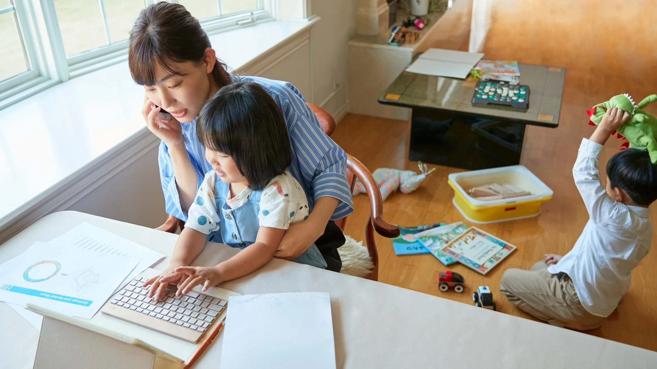 mom at work at home office with toddlers