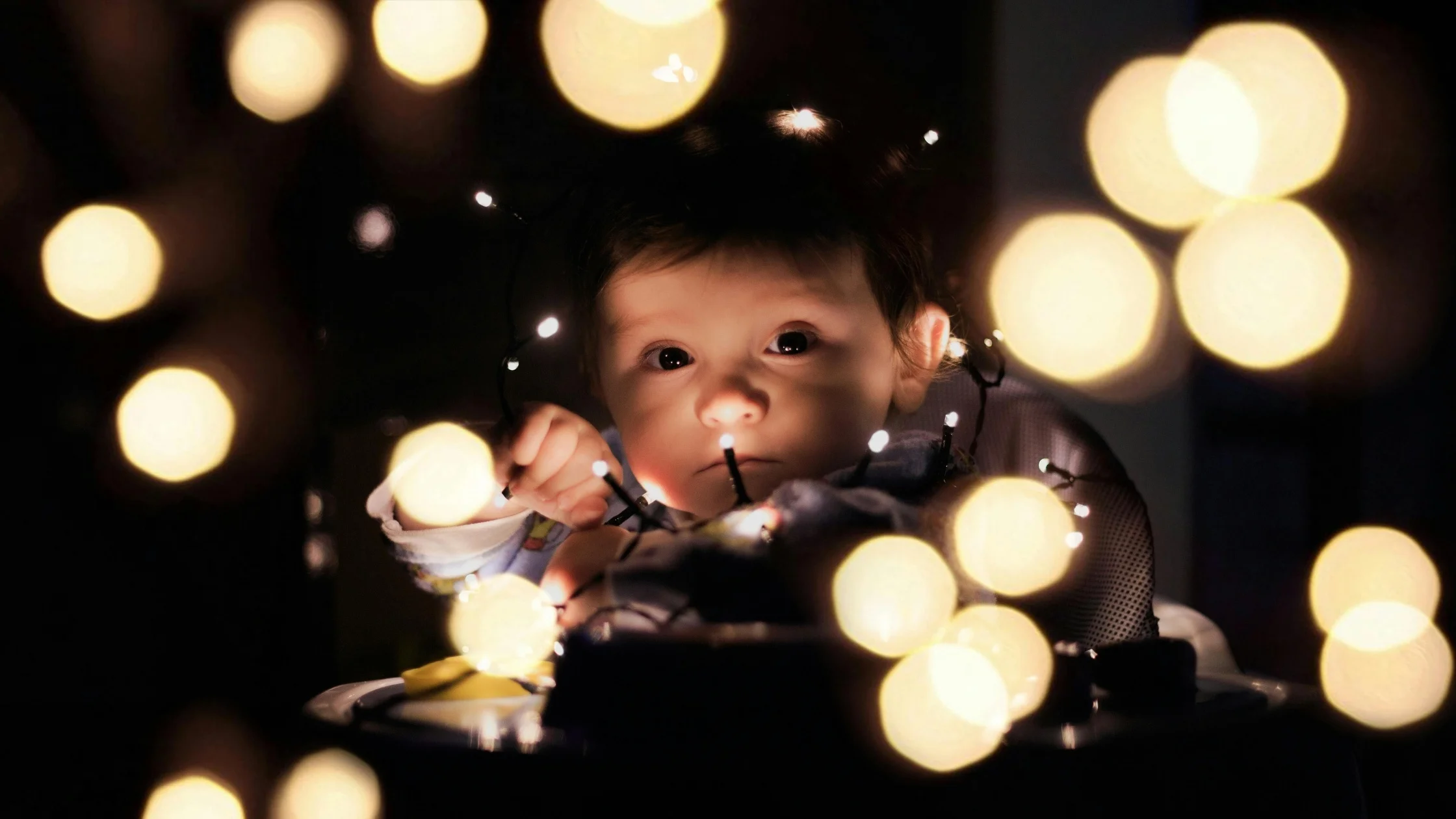 baby at night surrounded by little lights