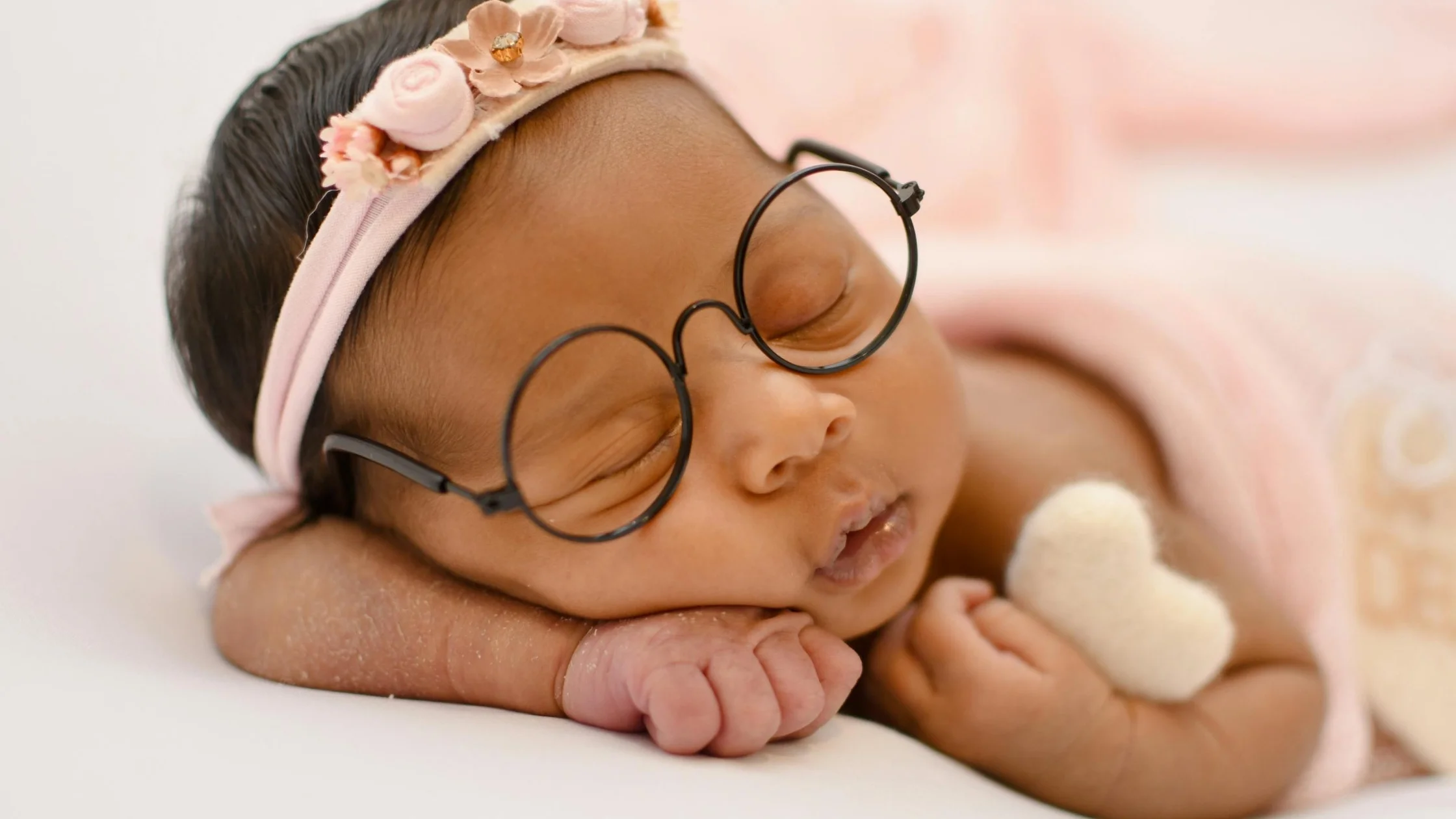 baby sleeping on pink blanket