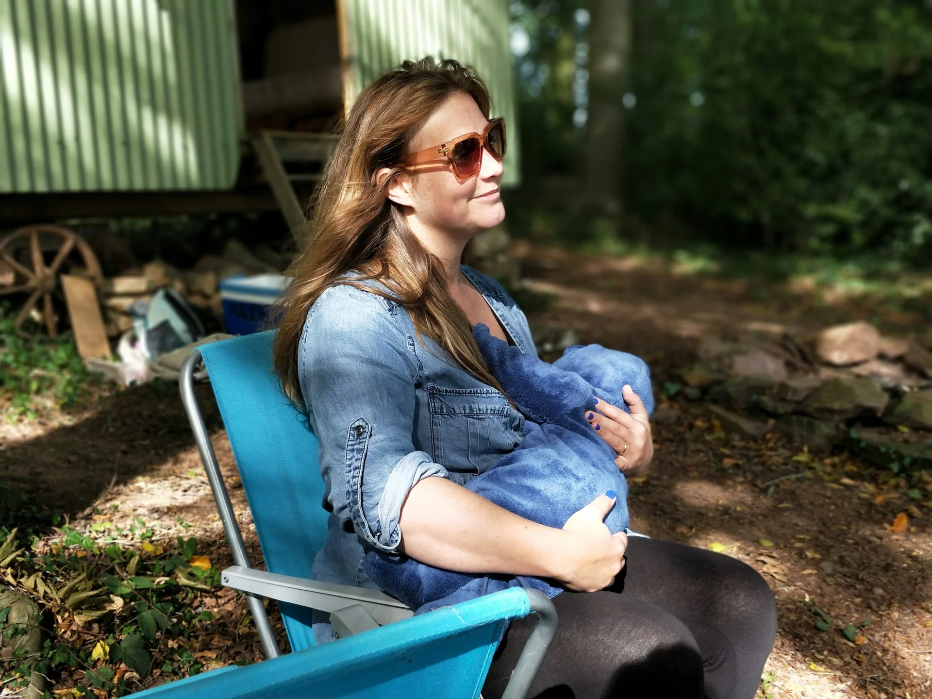 woman breastfeeding baby outside during daytime