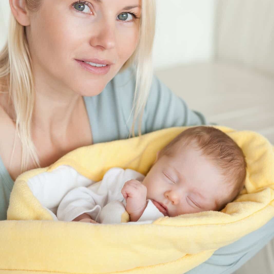 EW_mom-holding-her-sleeping-baby-that-is-wrapped-up-in-a-cover